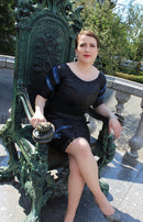 Model showcasing the Leather Noir Ensemble two-piece outfit with blue leather accents, seated on a decorative throne.